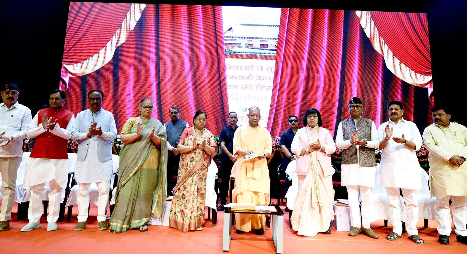 लखनऊ में आयोजित कार्यक्रम में मुख्यमंत्री योगी आदित्यनाथ ने 5,000 से अधिक आंगनवाड़ी कार्यकत्रियों और 60,000 सहायिकाओं की भर्ती का लक्ष्य घोषित किया। उन्होंने कहा कि अब पारदर्शी प्रक्रिया से नियुक्तियां हो रही हैं और कार्यकत्रियों को स्मार्टफोन व आधुनिक उपकरण दिए जा रहे हैं। सरकार ने PMJJBY, PMSBY और आयुष्मान भारत योजना के तहत सामाजिक सुरक्षा व स्वास्थ्य बीमा भी सुनिश्चित किया है। मुख्यमंत्री ने पूर्व सरकारों पर पोषाहार वितरण में माफिया नियंत्रण का आरोप लगाते हुए वर्तमान व्यवस्था को पारदर्शी बताया।