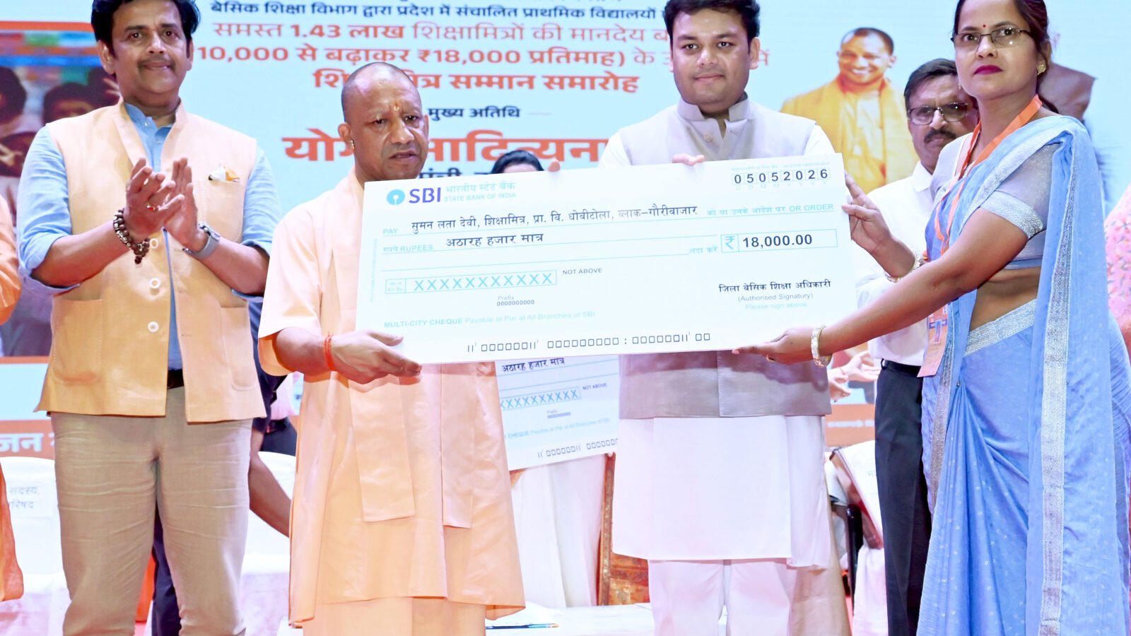 गोरखपुर में आयोजित राज्यस्तरीय शिक्षामित्र सम्मान समारोह में मुख्यमंत्री योगी आदित्यनाथ ने शिक्षामित्रों के मानदेय को ₹18,000 प्रतिमाह करने की घोषणा की। साथ ही 5 लाख रुपये का कैशलेस स्वास्थ्य बीमा, बैंक खातों के माध्यम से भुगतान और स्थानांतरण सुविधा देने की बात कही। उन्होंने पूर्व सरकारों पर नियमविरुद्ध नियुक्तियों का आरोप लगाया और शिक्षा सुधारों, निपुण भारत मिशन व आधुनिक स्कूल सुविधाओं का उल्लेख किया। मुख्यमंत्री ने शिक्षामित्रों से सकारात्मक सोच के साथ हर बच्चे को स्कूल तक पहुंचाने की अपील की।