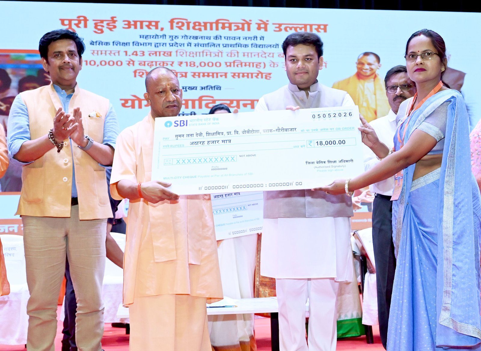 गोरखपुर में आयोजित राज्यस्तरीय शिक्षामित्र सम्मान समारोह में मुख्यमंत्री योगी आदित्यनाथ ने शिक्षामित्रों के मानदेय को ₹18,000 प्रतिमाह करने की घोषणा की। साथ ही 5 लाख रुपये का कैशलेस स्वास्थ्य बीमा, बैंक खातों के माध्यम से भुगतान और स्थानांतरण सुविधा देने की बात कही। उन्होंने पूर्व सरकारों पर नियमविरुद्ध नियुक्तियों का आरोप लगाया और शिक्षा सुधारों, निपुण भारत मिशन व आधुनिक स्कूल सुविधाओं का उल्लेख किया। मुख्यमंत्री ने शिक्षामित्रों से सकारात्मक सोच के साथ हर बच्चे को स्कूल तक पहुंचाने की अपील की।
