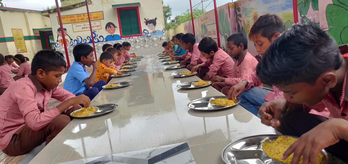 वाराणसी में योगी सरकार ने बेसिक शिक्षा विभाग के एक लाख से अधिक विद्यार्थियों तक गुणवत्तापूर्ण, पौष्टिक और गर्म भोजन पहुंचाने का लक्ष्य पूरा कर लिया है। पीएम पोषण योजना के तहत अब 850 प्राथमिक एवं उच्च प्राथमिक विद्यालयों के 1,06,502 बच्चों को अक्षय पात्र फाउंडेशन के माध्यम से भोजन मिल रहा है। एलटी कॉलेज परिसर की अत्याधुनिक केंद्रीयकृत रसोई से तैयार भोजन 65 रूट और विशेष वाहनों के जरिए महज चार घंटे में स्कूलों तक पहुंचाया जाता है।