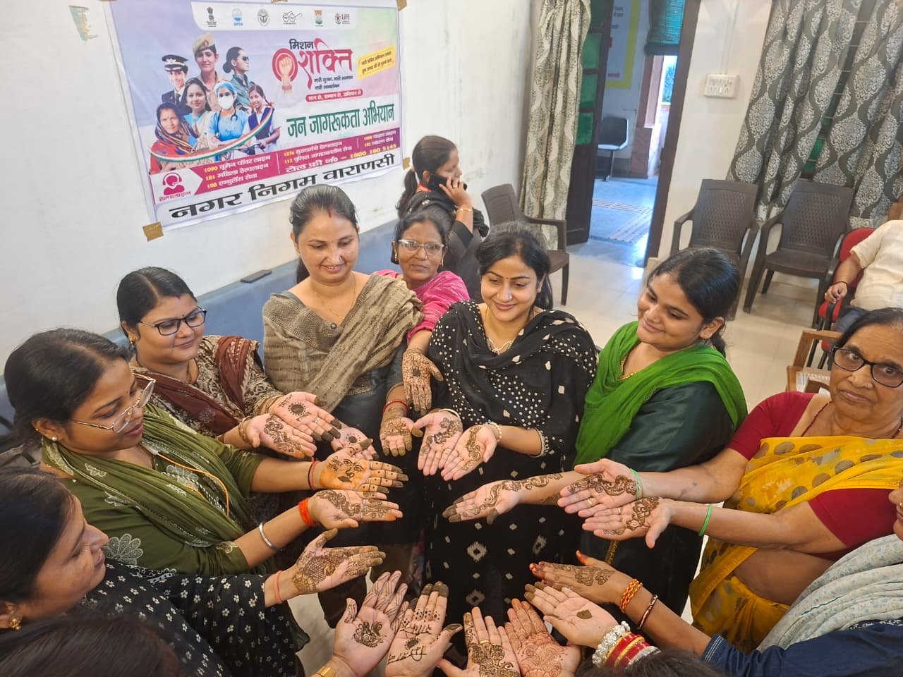 वाराणसी नगर निगम मुख्यालय में शनिवार को मिशन शक्ति विशेष अभियान के तहत मेहंदी प्रतियोगिता का आयोजन किया गया। इसमें विभिन्न श्रेणियों और आयु वर्ग की महिला कर्मचारियों ने उत्साहपूर्वक भाग लेकर अपनी रचनात्मक प्रतिभा का प्रदर्शन किया। डॉक्यूमेंट मैनेजर प्रीति सिंह और आईसी एक्सपर्ट सरिता तिवारी सहित कई महिला कर्मचारियों ने आकर्षक मेहंदी डिजाइन बनाए। आयोजन का उद्देश्य महिला सशक्तिकरण को बढ़ावा देना, महिलाओं की छिपी प्रतिभा को मंच प्रदान करना और कार्यस्थल पर आपसी सौहार्द मजबूत करना रहा।